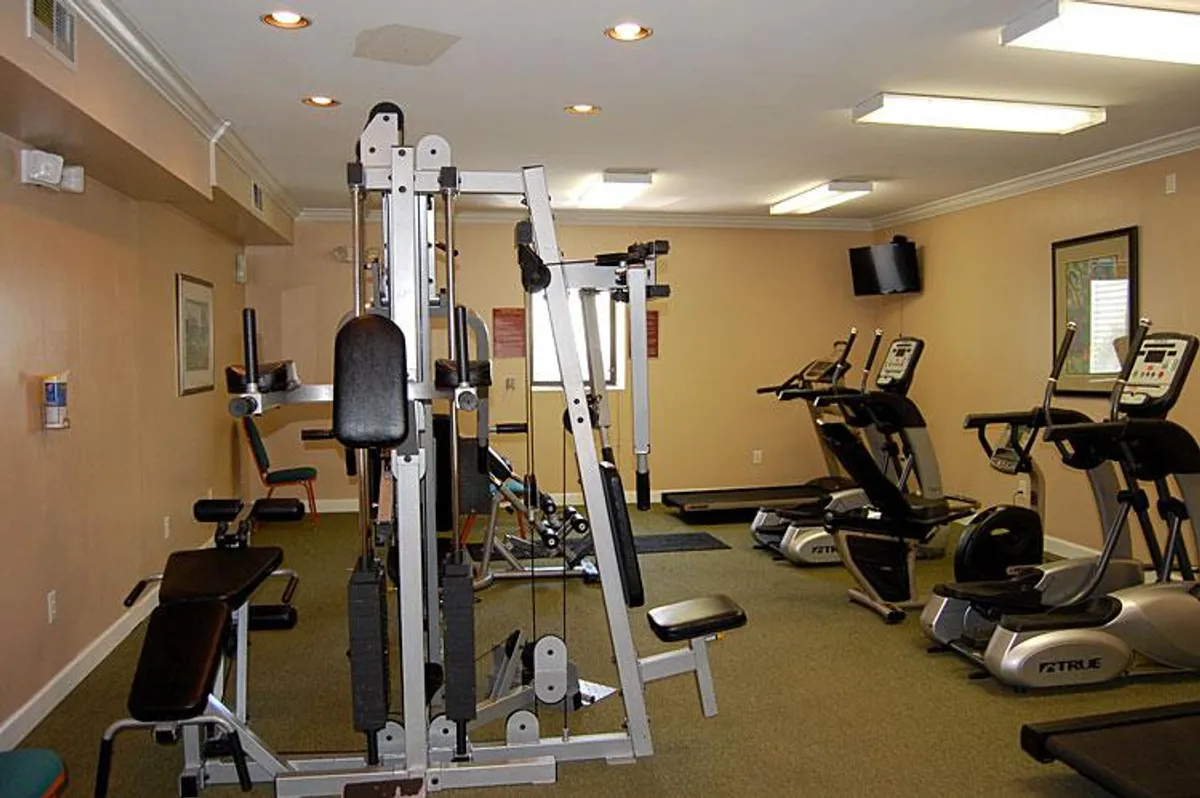 A modern fitness center equipped with weight machines, treadmills, and elliptical machines. The space is bright and motivational, inviting guests to keep active during their stay.